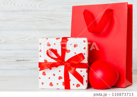 Shopping bag with gift box on colored background perspecrive view. Space for text holiday concept 110873713