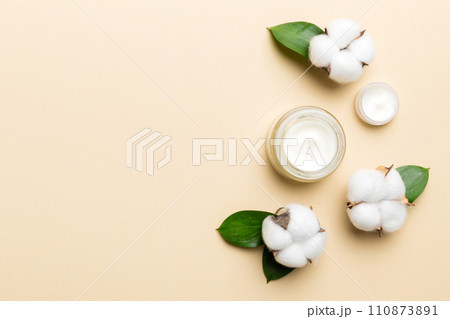 Organic cosmetic products with cotton flower and green leaves on color background. Copy space, flat lay 110873891