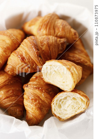 Fresh baked croissants on white table. 110873975