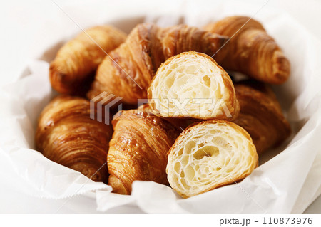 Fresh baked croissants on white table. 110873976