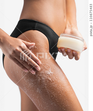 Woman applying scrub cosmetics on her skin Woman applying scrub cosmetics on her skin 110875483