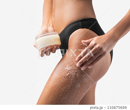 Woman applying scrub cosmetics on her skin Woman applying scrub cosmetics on her skin 110875689