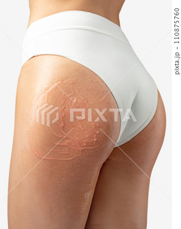 Pink care lotion applied on young woman buttock Pink care lotion applied on young woman buttock 110875760