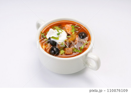 Traditional Russian soup solyanka in a white bowl on a white background Traditional Russian soup solyanka in a white bowl on a white background 110876109