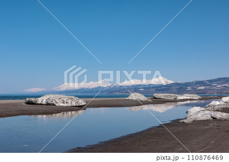 雪解け進む以久科原生花園浜辺から臨む知床連山 110876469