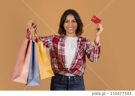 Young arab woman holding credit card and shopping bags Young arab woman holding credit card and shopping bags 110877503