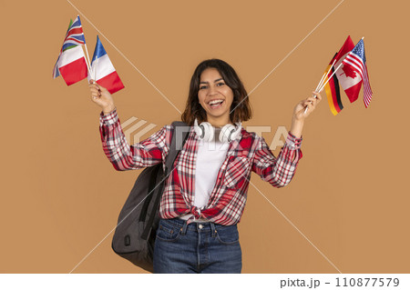 Cheerful young arab woman student with many different flags, smartphone 110877579