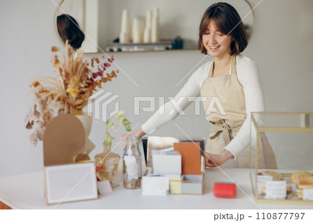 Smiling barista standing at the counter in coffee shop and takes orders. High quality photo Smiling barista standing at the counter in coffee shop and takes orders. High quality photo 110877797