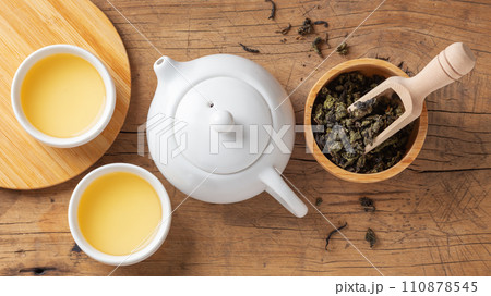 Tea set with teapot and tea leaves in bowl on wooden table, top view Tea set with teapot and tea leaves in bowl on wooden table, top view 110878545