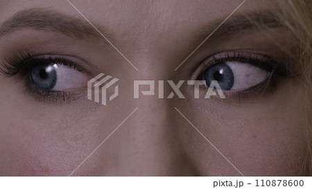 Woman with big blue eyes looks around. Close up of a woman with blue eyes. Macro of a woman's beautiful blue eyes. Extreme shallow depth of field with selective focus on center of eye. Woman with big blue eyes looks around. Close up of a woman with blue eyes. Macro of a woman's beautiful blue eyes. Extreme shallow depth of field with selective focus on center of eye. 110878600