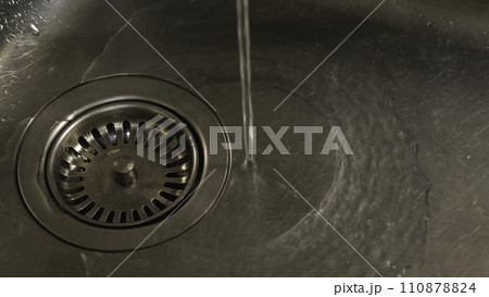 View of the water running from the tap to kitchen sink. Concept. Close-up 110878824