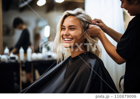 Young female hairdresser fixing hair of gorgeous smiling woman with hairspray. Hairdress and beauty concept 110879006