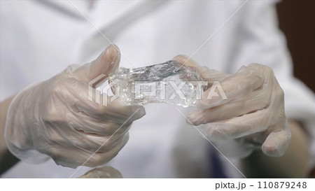 Natural stone amethyst or another mineral, stone. Wild amethyst in female hands in white gloves. Rock stone in hands 110879248