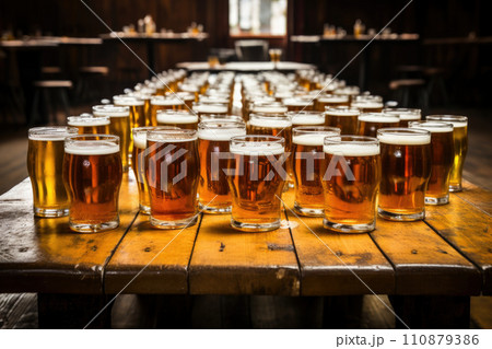 Cold mugs and glasses of beer on the old wooden table at the black background. Assortment of beer 110879386