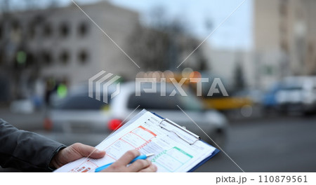 Man on street fills out an accident statement Man on street fills out an accident statement 110879561