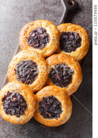 Cebularz Lubelski Polish Onion poppy Flatbread close-up on a wooden board. Vertical top view 110879986