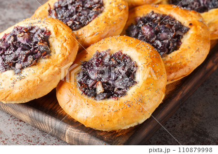 Cebularz Lubelski is a round-shaped Polish Onion poppy flatbread close-up on a wooden board. Horizontal Cebularz Lubelski is a round-shaped Polish Onion poppy flatbread close-up on a wooden board. Horizontal 110879998