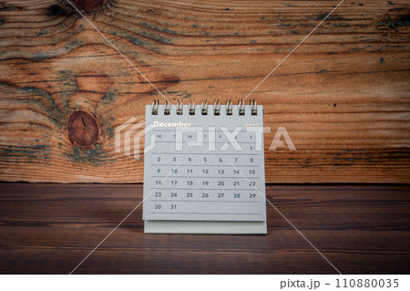 DECEMBER 2024. Cardboard desk calendar on a wooden texture background 110880035