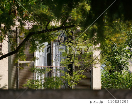 Balcony of an Italian style house in a modern house. Sunny day in a green garden Balcony of an Italian style house in a modern house. Sunny day in a green garden 110883295