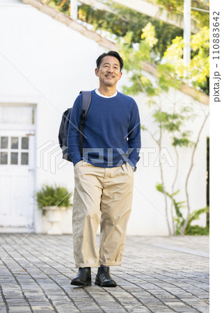 リュックを肩にかけた笑顔の50代の男性　 110883642