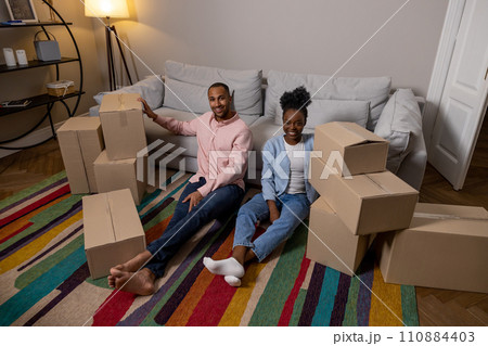 Couple moving to new house together holding boxes parcel enjoying relocation Couple moving to new house together holding boxes parcel enjoying relocation 110884403