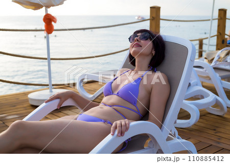 Business woman on vacation sunbathing while lying on a hammock Business woman on vacation sunbathing while lying on a hammock 110885412