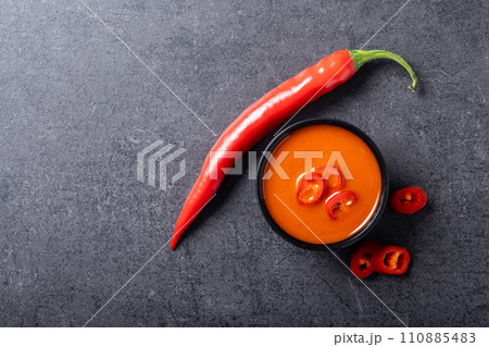 Spicy chili sauce in bowl on black background Spicy chili sauce in bowl on black background 110885483