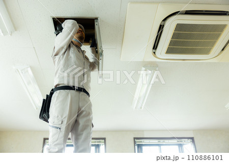 天井裏を点検する作業着の男性 110886101