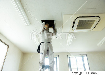 天井裏を点検する作業着の男性 110886106