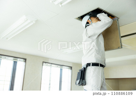天井裏を点検する作業着の男性 110886109