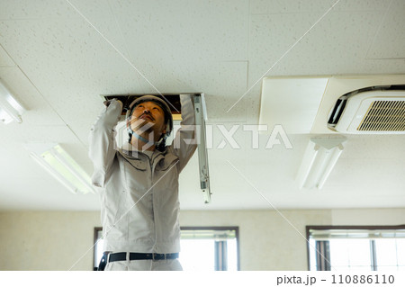 天井裏を点検する作業着の男性 天井裏を点検する作業着の男性 110886110