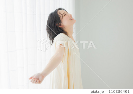 朝の日差しを浴びる若い女性 110886401
