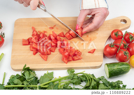 Chopped tomatoes on a cutting board for preparing a vegetable salad. 110889222