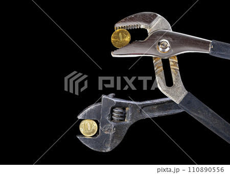 Allegory of the global financial crisis - Iron 10 rubles coin (written ten rubles, Bank of Russia in the Russian) in the grip of economic crisis, on a black background. Finance and business concept 110890556