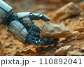 hand of a humanoid robot picks up a mineral sample from the surface of the planet 110892041