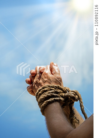 Rope tied hands on sky background 110892116