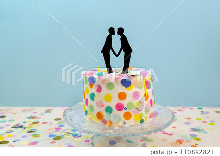 Two grooms cake toppers on decorated wedding cake. Gay wedding concept LGBTQIA Two grooms cake toppers on decorated wedding cake. Gay wedding concept LGBTQIA 110892821
