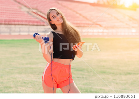 Young, beautiful girl athlete in sportswear is training at the stadium Young, beautiful girl athlete in sportswear is training at the stadium 110893051