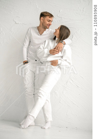 A young couple in love stands against the wall, looking at each other tenderly and lovingly. Valentine's Day A young couple in love stands against the wall, looking at each other tenderly and lovingly. Valentine's Day 110893908