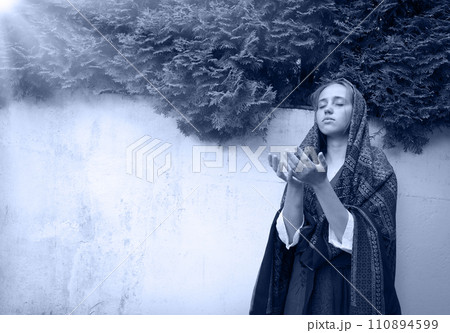 Praying girl in the yard 110894599