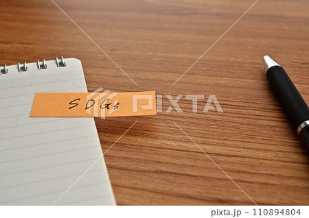 SDGsと書かれた付箋がメモ帳に貼られている 110894804