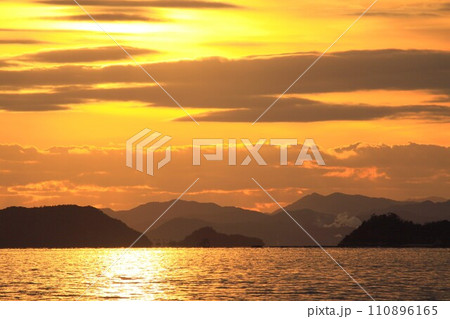 夕日に染まる空と海 110896165