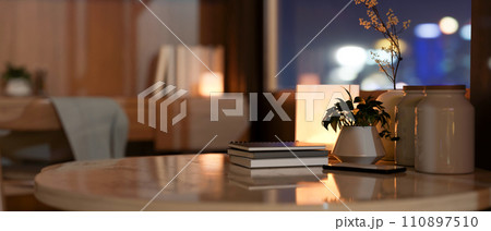 A copy space and accessories on a coffee table in a modern, cosy living room at night. 110897510