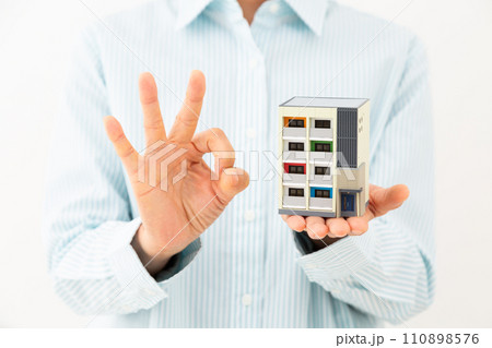 マンションの住宅模型を持って丸サインをするミドル女性 110898576