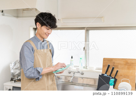 台所でお皿を拭いて、家事をする若い男性　家事代行 110899139