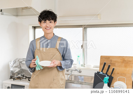台所でお皿を拭いて、家事をする若い男性 家事代行 台所でお皿を拭いて、家事をする若い男性 家事代行 110899141