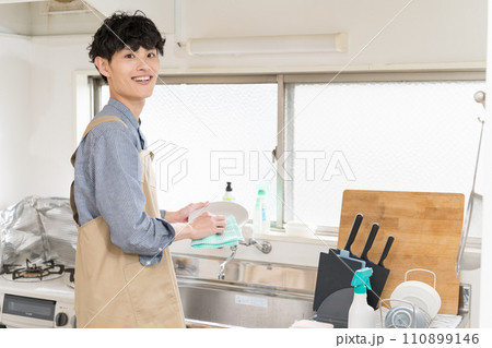 台所でお皿を拭いて、家事をする若い男性　家事代行 110899146