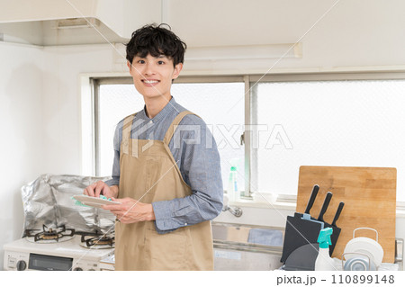 台所でお皿を拭いて、家事をする若い男性 家事代行 台所でお皿を拭いて、家事をする若い男性 家事代行 110899148