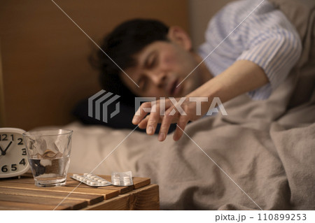 睡眠薬 不眠症 薬を飲もうとする男性 睡眠薬 不眠症 薬を飲もうとする男性 110899253