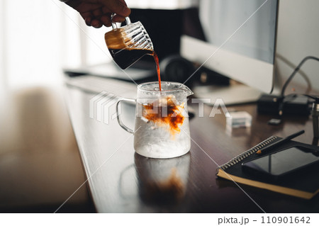 Iced coffee in a glass mug on the work desk Iced coffee in a glass mug on the work desk 110901642